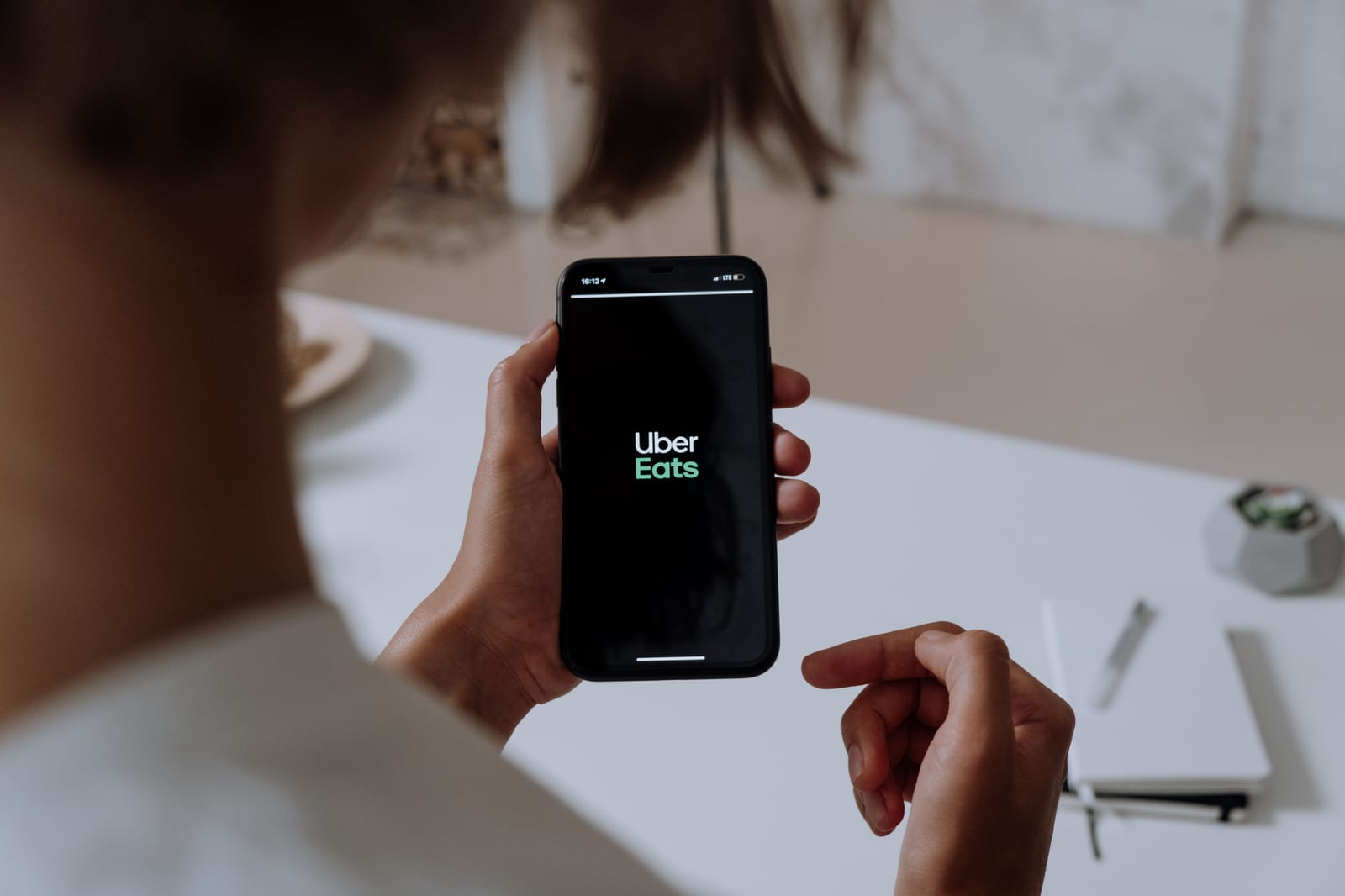Customer using Uber Eats on smartphone to place restaurant order