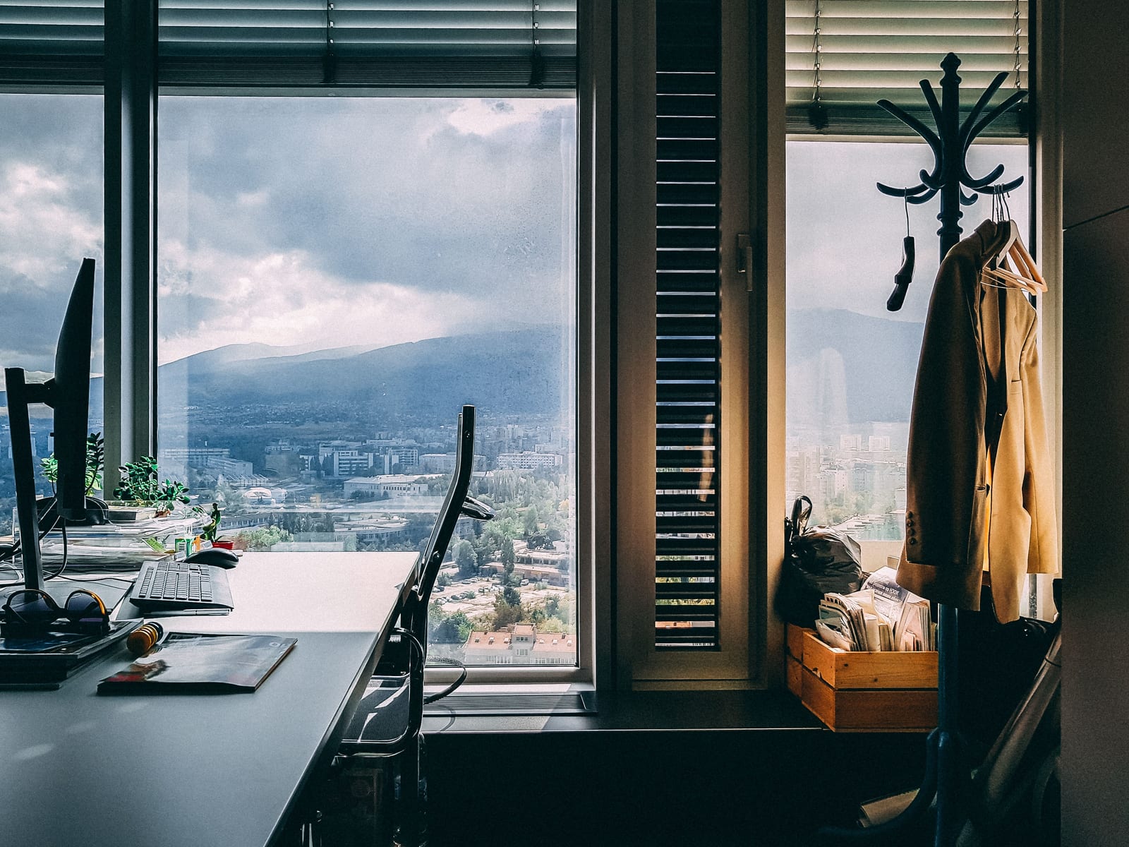 A contemporary office setting with a stunning mountain view through large windows and stylish furnishings.